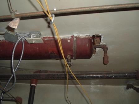 From the evidence files of the Orillia home inspector. biz-heating info.   As an Orillia home cottage and commercial inspector I will sometimes come across abandoned Wiring, ductwork, and gas or water pipe. These photos show two large tanks that are strapped to the ceiling . These tanks are air expansion tanks for abandoned steam or hot water heating systems. One is noticeably larger and came from a commercial inspection around Orillia and the other was also a commercial inspection from further north in Muskoka. Of the two the one with the largest tank, it was about four feet long, also has the much larger pipe in the background. This is due to the larger one being for steam heat. When converting water to steam it expands to 270 times the original volume and thus the larger pipe as well. These types of installations are clues to look for things left behind as well. 